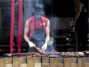 Dillon Pfeffer barbecues some ribs and chicken at the Oak and Barrel on ribbers row during the final day of London Rifest on Monday August 6, 2018. (Derek Ruttan/The London Free Press)