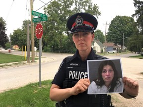 Constable Sandasha Bough holds a photo of Kathryn Bordato who was last seen nine years ago at the intersection of Walnut Street and Cavendish Crescent in London. (Derek Ruttan/The London Free Press)