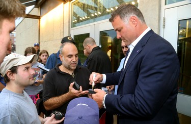 Eric Lindros signs a puck for Spiro Theologos as he arrives for Logan Couture's All in for Brain Research charity casino night at Centennial Hall in London, Thursday.  Mike Hensen/The London Free Press/Postmedia Network