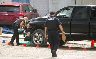 London police forensic officers take samples from the front of a black pickup truck involved in an incident on Kitchener Avenue in London, Ont. on Tuesday August 21, 2018. (MIKE HENSEN, The London Free Press)
