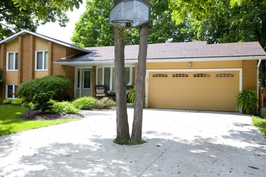 Net gain: Even when there is not a full-court press in the front yard of this London home on Blue Ridge Crescent, the beautiful Byron property commands a second look with a shagbark hickory tree creatively left to grow smack in the middle of the driveway. (MIKE HENSEN, The London Free Press)