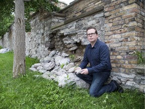 Mike Bloxam, former president of Architectural Conservancy of Ontario, London chapter, surveys damage at the old retaining wall between the former Middlesex County courthouse and historic old jail in London on Thursday. (Derek Ruttan/The London Free Press)