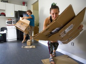 Amber Lapinsky, left, and family friend Lara Lipworth flatten boxes after unpacking Lapinsky's kitchen belongings at her new residence on Fleming Drive in London.  Lapinsky, 18, and her roommate Shanna Hayward, 19, are moving off campus for their second year at Fanshawe College. Mike Hensen/The London Free Press/Postmedia Network