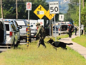 Police officers survey the area of a shooting in Fredericton, N.B. on Friday, August 10, 2018. P