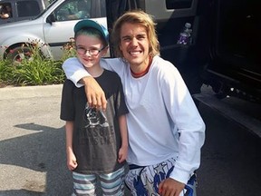 Pop superstar Justin Bieber poses wtih eight-year-old fan Zenan White Sunday while in the parking lot of a Stratford Tim Hortons. JANELLE WHITE/Special to Postmedia Network
