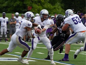 Western Mustangs quarterback Chris Merchant hands the football to running back Alex Taylor during an Ontario University Athletics football regular-season game against the Carleton Ravens at Carleton's MNP Park on Sunday. Western won 26-23 in overtime. Valerie Wutti/Carleton Ravens