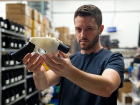 In this file photo Cody Wilson, owner of Defense Distributed company, holds a 3D printed gun, called the "Liberator", in his factory in Austin, Texas on August 1, 2018. The Texas man who has played a central role in the U.S. debate over 3D-printed weapons and caused panic by publishing firearm blueprints online, has been arrested and charged with having sex with a 16-year-old. (KELLY WEST/AFP/Getty Images)