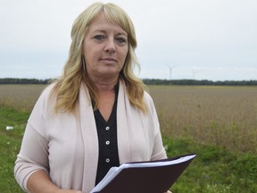 Kristen Rodrigues stands near the Cedar Point II Wind Energy Centre northeast of Sarnia, in operation since October 2015. With the end of the Green Energy Act Rodrigues and others have renewed their calls for stricter testing around turbines, testing they say is based on faulty regulations. (Louis Pin/The Observer)