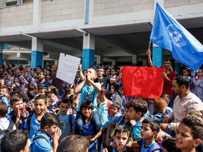 Palestinian children chant slogans and raise the victory gesture during a protest at a United Nations Relief and Works Agency (UNRWA) school, financed by US aid, in the Arroub refugee camp near Hebron in the occupied West Bank on Sept. 5, after the United States, the biggest contributor to the UNRWA -- a lifeline for millions of Palestinians for over 70 years -- announced on Aug. 31 it is halting its funding to the organization, which it labelled "irredeemably flawed". (HAZEM BADER/AFP/Getty Images)