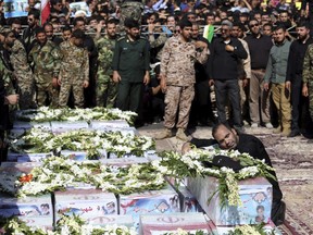 The father of a 4-year-old boy killed in Saturday's terror attack on a military parade, mourns over his coffin during a mass funeral for the victims, in Ahvaz, Iran, on Mondat. (Ebrahim Noroozi/AP Photo/)