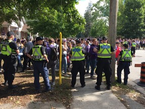 Police officers kept students from reaching parts of Broughdale Avenue in London Saturday morning. Eventually, in the face of a huge crowd and students sneaking past through back yards, police opened the roadway.