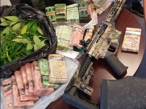 The OPP seized guns, cash and marijuana during to searches at the Chippewas of the Thames First Nation. (Police supplied photo)