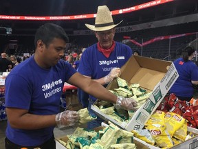3M volunteers Mitesh Chaudhari, left, and Bill LaBranche replenish the stockpile of salt and vinegar chips at the United Way Elgin Middlesex Harvest Lunch Thursday.