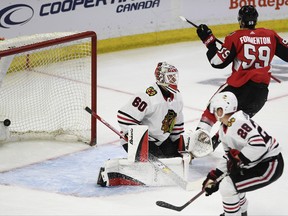 Ottawa Senators' Alex Formenton (59) scores on Chicago Blackhawks goaltender Collin Delia (60) as Blackhawks' Henri Jokiharju (28) skates past, during the first period of a pre-season NHL hockey game in Ottawa, Friday September 21, 2018. THE CANADIAN PRESS/Justin Tang