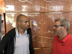 Decathlete Damian Warner chats with coach Gar Leyshon at a news conference at One London Place Friday to announce that Warner is returning to London to train. (Paul Vanderhoeven/The London Free Press)