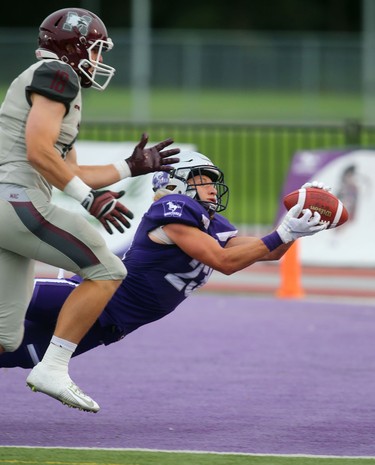 Western Mustangs safety Daniel Valente Jr. stretches out to make an interception in his end zone on a pass intended for McMaster slotback Dylan Astrom in Western's 44-6 home opening win over the Marauders in London, Ont. 
Photograph taken on Saturday September 8, 2018. 
Mike Hensen/The London Free Press/Postmedia Network