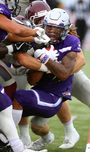 Western running back Cedric Joseph keeps digging for yards as he's wrapped up during the first half of Western's home opener on Saturday September 8, 2018. 
Western won 44-6 over the McMaster Marauders.
Mike Hensen/The London Free Press/Postmedia Network