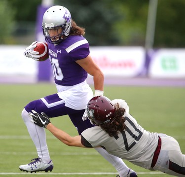 Western kick returner Mike Sananes straight arms McMaster cornerback Patrick Cupido in Western's 44-6 home-opening win over the Marauders in London, Ont. 
Photograph taken on Saturday September 8, 2018. 
Mike Hensen/The London Free Press/Postmedia Network