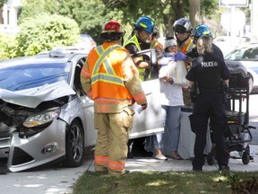 Paramedics tend to the driver of a car that collided with a fruit delivery truck at the intersection of Grey and Waterloo streets in London on Saturday Sept. 1. The driver was taken to hospital with injuries not considered life threatening.  The truck driver was unharmed. Derek Ruttan/The London Free Press