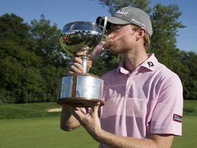 Danny Walker with the Freedom 55 Financial Championship trophy after finishing the Highland Country Club tournament with score of 19 under par in London. (Derek Ruttan/The London Free Press)