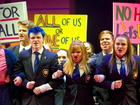 Marc Hall played by blue-haired Devon Dixon and Marcy Gallant (centre) as Carly link arms with supporters during a scene from Grand Theatre's High School Project production of Prom Queen: The Musical (Mike Hensen/The London Free Press)