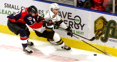 Billy Moskal of the London Knights is  chased by Grayson Ladd as he carries the puck behind the Windsor Spitfires net during the Knights home opener at Budweiser Gardens Friday Sept. 21.  Mike Hensen/The London Free Press