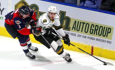 Billy Moskal of the London Knights is  chased by Grayson Ladd as he carries the puck behind the Windsor Spitfires net during the Knights home opener at Budweiser Gardens Friday Sept. 21.  Mike Hensen/The London Free Press