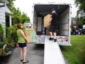 People load a U-Haul truck with boxes while they prepare to move in. (Chris Dunn/The Associated Press)