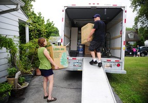 People load a U-Haul truck with boxes while they prepare to move in. (Chris Dunn/The Associated Press)
