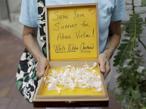 Irene Youngman holds a box of ribbons to be given away before a mass led by Bishop Ronald Gainer, of the Harrisburg Diocese, at the Cathedral Church of St. Patrick in Harrisburg, Pa., last month. A grand jury report released last month found rampant sexual abuse of more than 1,000 children by about 300 priests in six Pennsylvania dioceses over seven decades.(Matt Rourke/AP Photo)