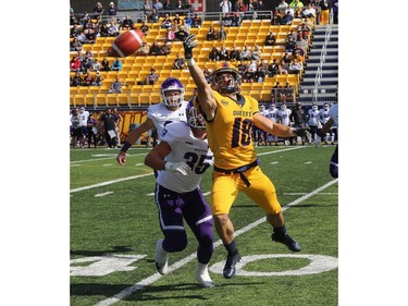 Queen's Golden Gaels Matteo Del Rocco reaches for a pass meant for Western Mustangs Michael Moore, earning himself a pass a pass interference penalty during their Ontario University Athletics football game in Kingston Saturday Sept. 9 2018. Western won 26-23.   Ian MacAlpine/Postmedia Network