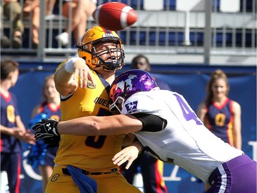 Queen's Golden Gaels quarterback Nate Hobbs feels pressure from Western Mustangs Trey Humes during their Ontario University Athletics football game in Kingston Saturday Sept. 9 2018. Western won 26-23.   Ian MacAlpine/Postmedia Network