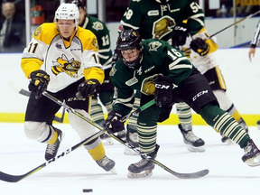 Sarnia Sting player Cameron Hough (11) and Sean McGurn (16) of the London Knights battle for the puck in the first period of an OHL preseason game at Progressive Auto Sales Arena in Sarnia, Ont., on Saturday, Sept. 1, 2018. Mark Malone/Postmedia