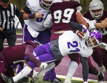 The Western Mustangs were in Ottawa to play the uOttawa Gee-Gees Saturday October 13, 2018 at the Gee-Gees Field. Western Mustangs #21 Cedric Joseph holds the ball while getting tackled.   Ashley Fraser/Postmedia