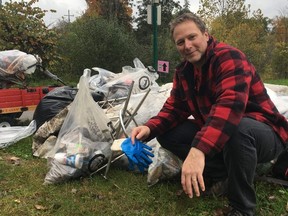 Thames River cleanup co-organizer Wes Kinghorn shows off the garbage collected in just a few hours Saturday from the banks of the river in downtown London.