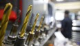 Various cutting and drilling bits are lined up as Cameron Milne works programming a computer numerical control (CNC) mill at Armo Tool near Delaware. (Mike Hensen/The London Free Press)