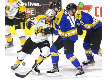 London Knight Alex Turko tangles with Mitch Eliot of the Sarnia Sting during the first period of their OHL hockey game in London on Friday Oct. 12, 2018. The Knights were sporting custom sweaters in support of the Dream Lottery which raises money for London hospitals. The sweaters will be auctioned off at http://auction.chl.ca/ Derek Ruttan/The London Free Press