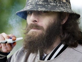 Eric Rook enjoys a strain of marijuana called NYC Diesel  in Victoria Park  in London. (Derek Ruttan/The London Free Press)