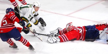 Dalton Duhart of the Knights tries to get his stick on a loose puck but it's smothered by goaltender Kyle Keyser of the Oshawa Generals as Nando Eggenberger moves in to tie up Duhart in the first period of their game at Budweiser Gardens on Friday October 19, 2018.  Mike Hensen/The London Free Press/Postmedia Network