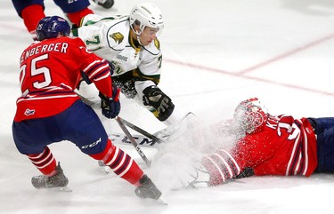 Dalton Duhart of the Knights tries to get his stick on a loose puck but it's smothered by goaltender Kyle Keyser of the Oshawa Generals as Nando Eggenberger moves in to tie up Duhart in the first period of their game at Budweiser Gardens on Friday October 19, 2018.  Mike Hensen/The London Free Press/Postmedia Network