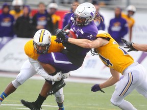 Western Mustangs running back Cedric Joseph gets spun around by Laurier's Daishane Johnson and Scott Hutter in Western's 46-13 win over the Hawks Saturday at TD Stadium.
(Mike Hensen/The London Free Press)