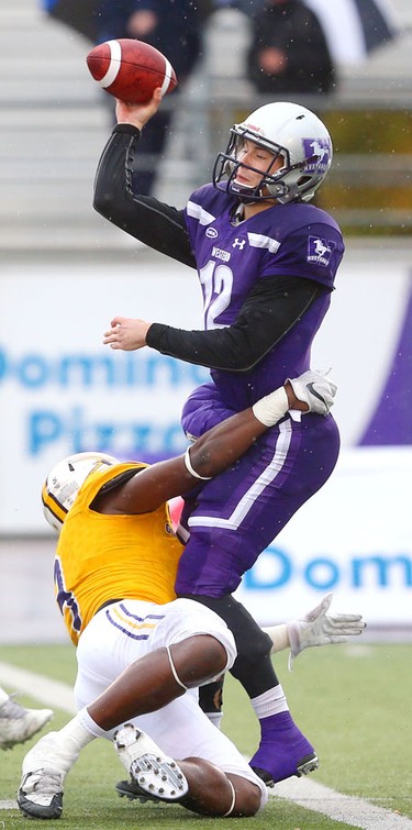 Western quarterback Chris Merchant throws before nearly being sacked by Laurier defensive end Robbie Smith in the Western Homecoming game on Saturday October 20, 2018 at TD stadium.
The Mustangs won 46-13 after a strong second half against the Golden Hawks, leaving them undefeated for the season.
Mike Hensen/The London Free Press/Postmedia Network