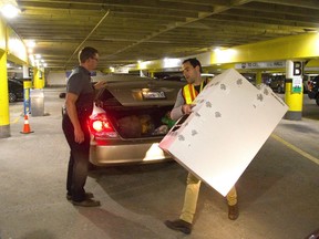 Iain Sullivan, of the City of London election crew, hauls a ballot box into city hall's basement Monday night from the trunk of a driver who brought the ballots from a polling station. (Mike Hensen/The London Free Press)