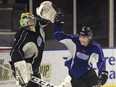 London Knights winger Cole Tymkin high fives goalie Joesph Raaymakers during team practice. (Derek Ruttan/The London Free Press)