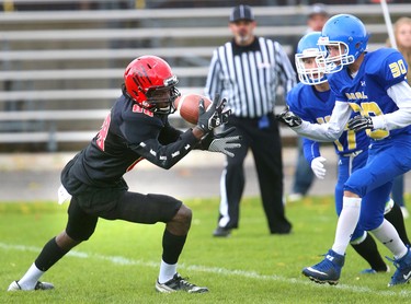 CJ Jenkins of Saunders secondary school juggles a pass in front of Tyson Hartling and Ian Proszowski of Beal but manages to pull it in during their TVRA Central quarter-final playoff game at Beal on Wednesday, Oct. 24, 2018. 
Mike Hensen/The London Free Press