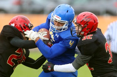 Geoffrey Clubine, of Beal secondary school, rated by his coach Joe Leckie as one of the best high school running backs in the city, tries to battle through the tackles of Nathan Laforge and Matt Fradgely of Saunders during their TVRA Central quarter-final playoff game at Beal on Wednesday, Oct. 24, 2018. 
Mike Hensen/The London Free Press