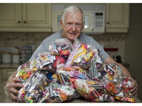 George Smith shows a few of the kilogram bags of candy he has assembled to give to children on Hallowe'en night. This may be Smith's last year for the practice. (Derek Ruttan/The London Free Press)