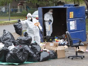 Police dig through the contents of a garbage dumpster in search of evidence in their investigation of a shooting in the parking lot of the Marconi Boulevard complex on Oct. 28. (Derek Ruttan/The London Free Press)