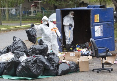 Police dig through the contents of a garbage dumpster in search of evidence in their investigation of a shooting in the parking lot of 235 Marconi Blvd. Derek Ruttan/The London Free Press/Postmedia Network