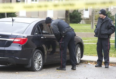 Police were busy searching for evidence in their investigation of a shooting in the parking lot of 235 Marconi Blvd. Derek Ruttan/The London Free Press/Postmedia Network